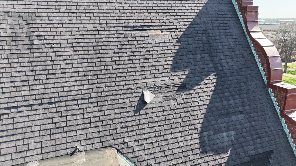Aerial drone view of wind-damaged shingles