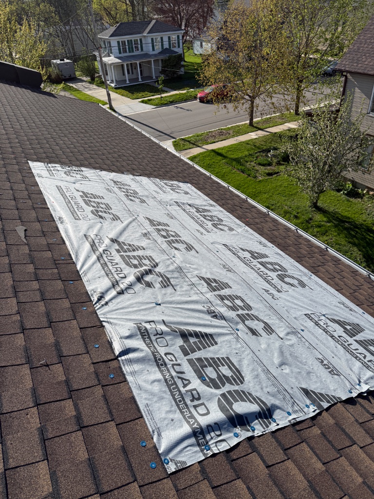 Emergency roof tarp — synthetic underlayment protecting exposed shingles after storm damage
