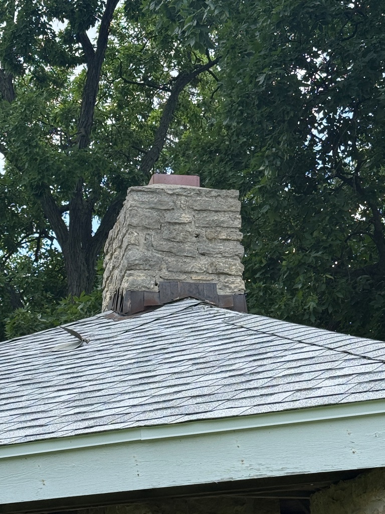 Curled and lifted shingle tab from wind damage at ridge