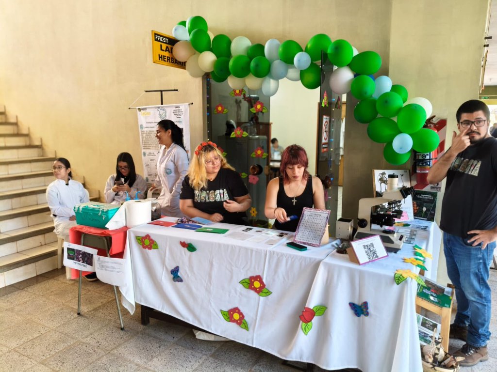 Equipo de LAREV atendiendo el stand con arco de globos en SeCien 2026