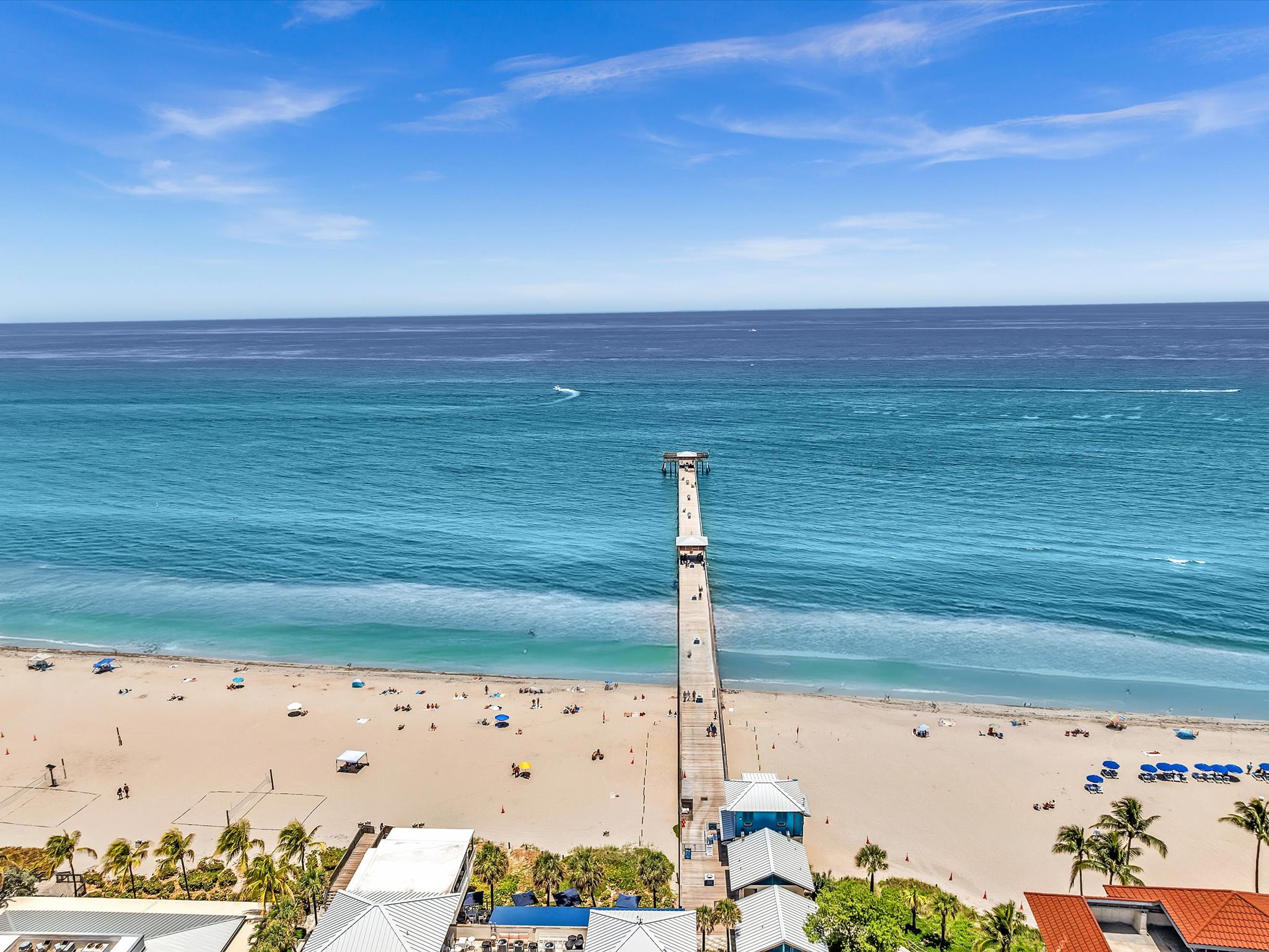 Deerfield Beach International Fishing Pier extending into turquoise Atlantic water, viewed from above the beach