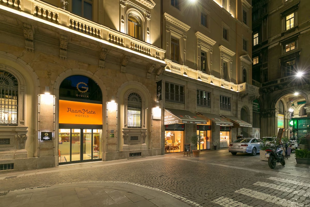 Milan design hotel exterior at night — former bank headquarters near Piazza del Duomo