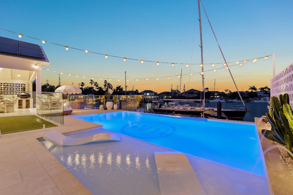 Seahaven Court — resort pool at dusk with string lights and marina views