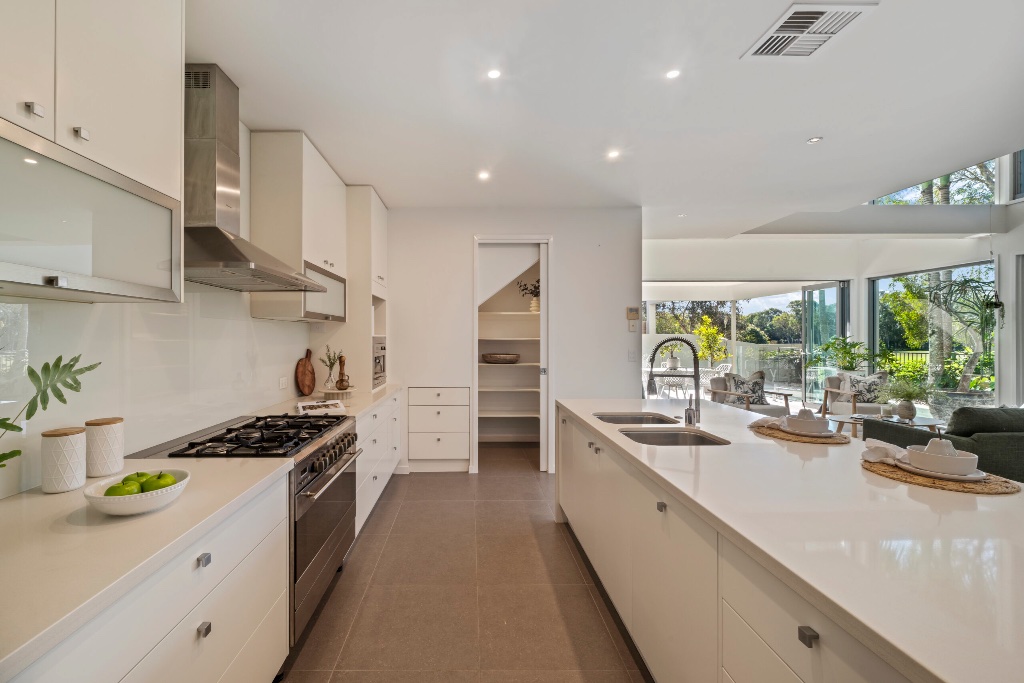 Resort residence — kitchen with stone benchtop and garden views