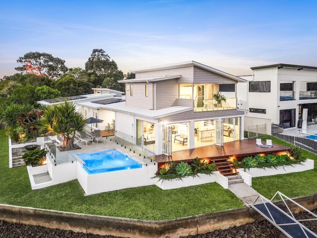 Waterfront estate — aerial dusk view with pool