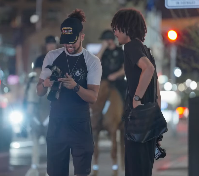 Photographer sharing camera photographs during a nighttime street photography session.