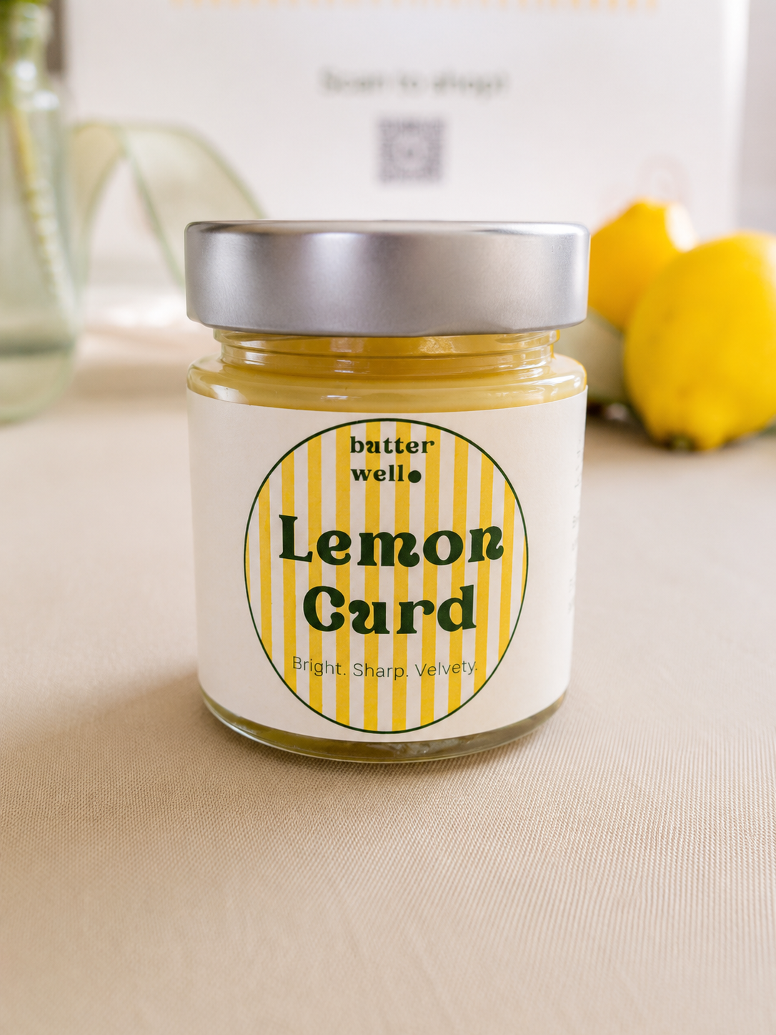 A jar of Butter Well Lemon Curd with lemons