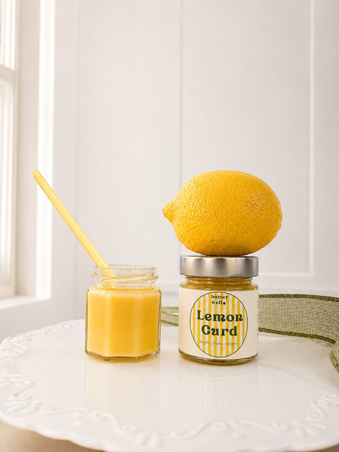 Butter Well lemon curd jars on a white cake stand
