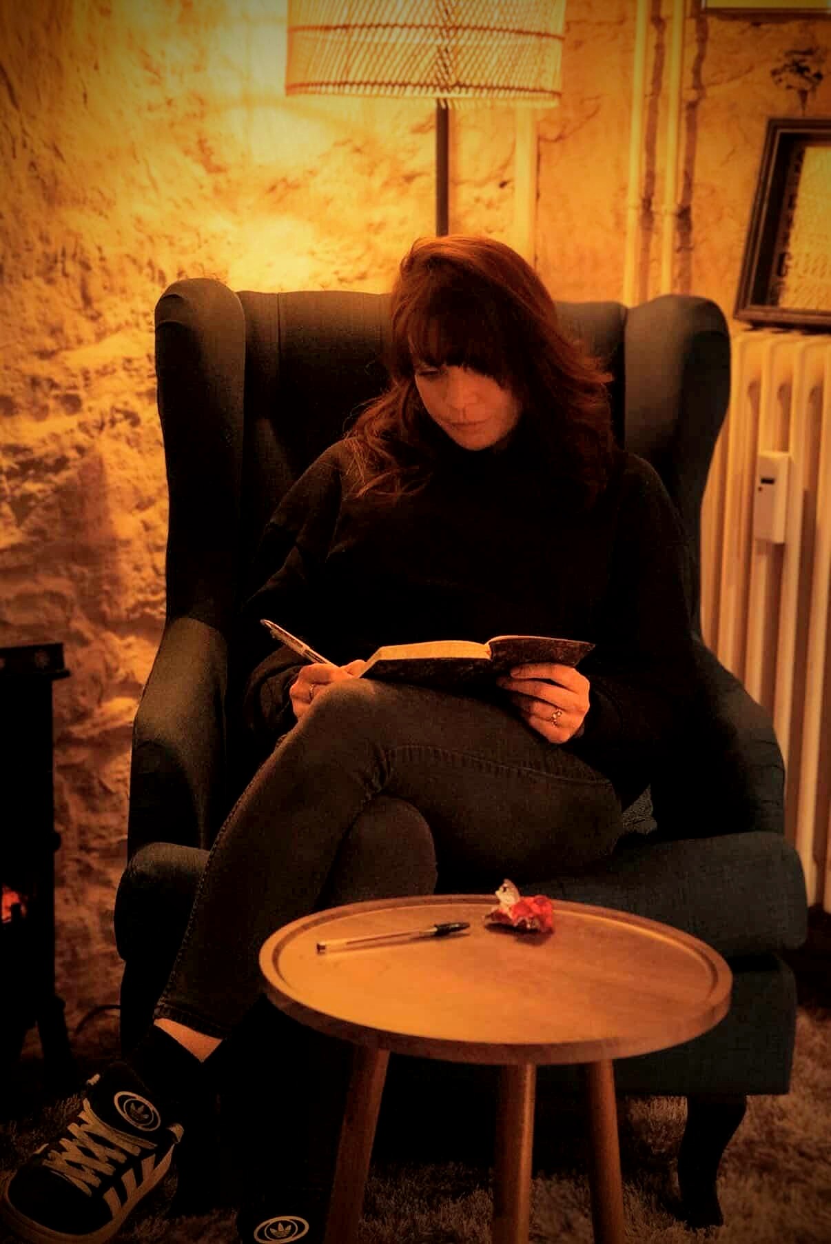 A woman writing in a notebook at a writing workshop at the Cosh Cafe in Basel