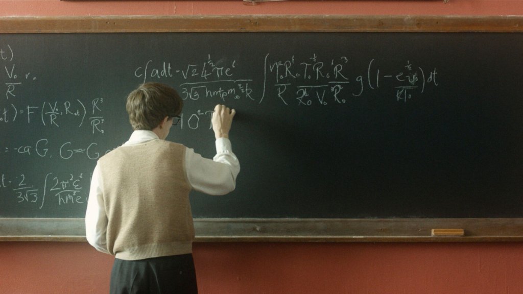 Person writing equations on a chalkboard