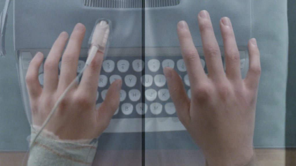 Hands on a typewriter — M continuing Marie's research