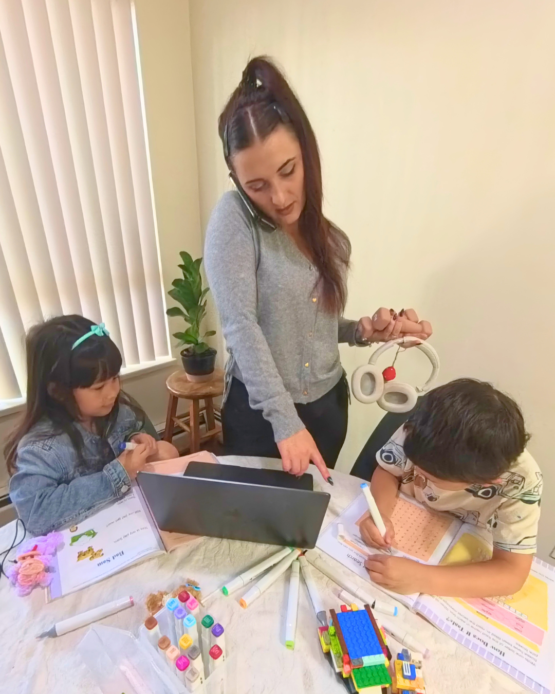 Nissi helping her kids with schoolwork at the kitchen table