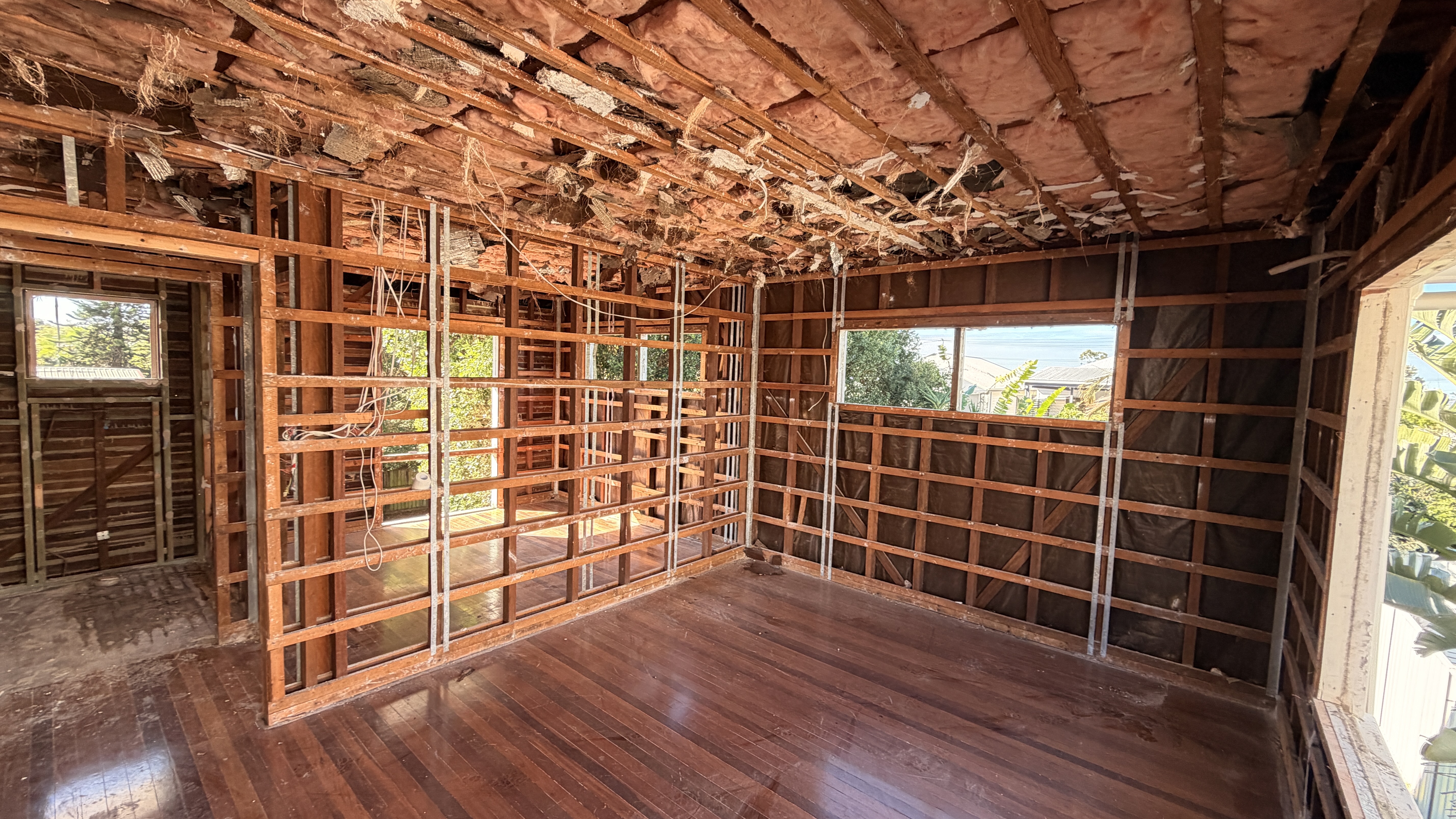 Room gutted to framing with insulation exposed