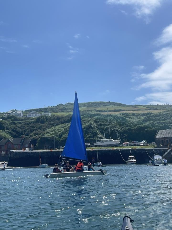 Scouts sailing a small boat in the bay