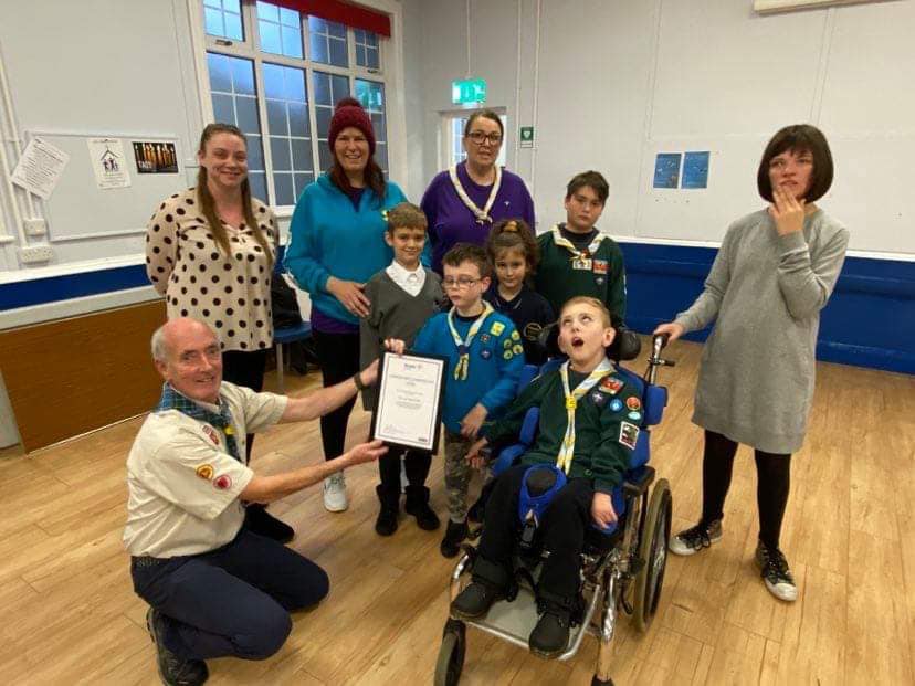 Scout receiving an award with family and leaders