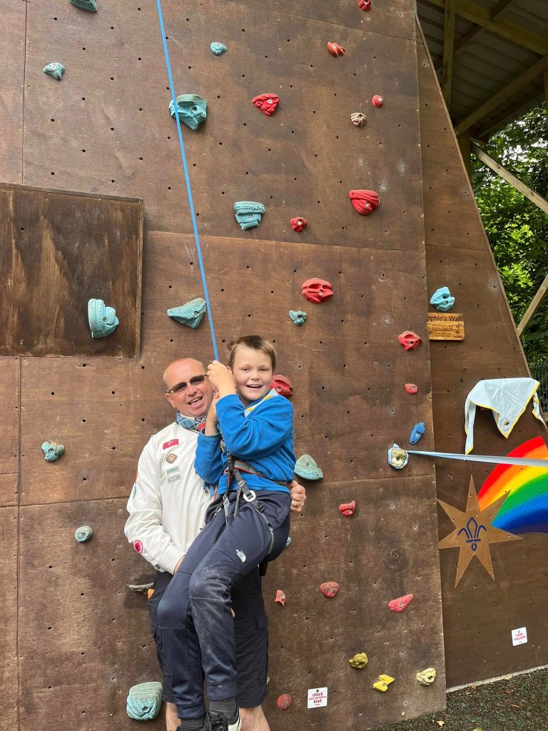 Scout on a climbing wall with leader