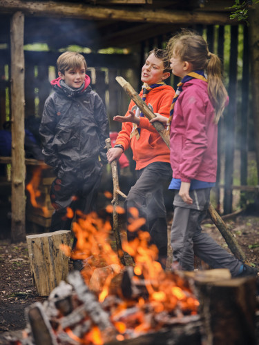Scouts around a campfire at dusk