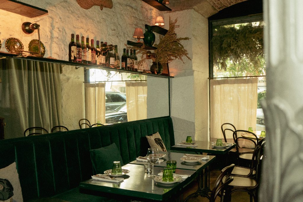 Rincón íntimo con sofás de terciopelo verde en Terry's Bar, bar de vinos en Salamanca, Madrid