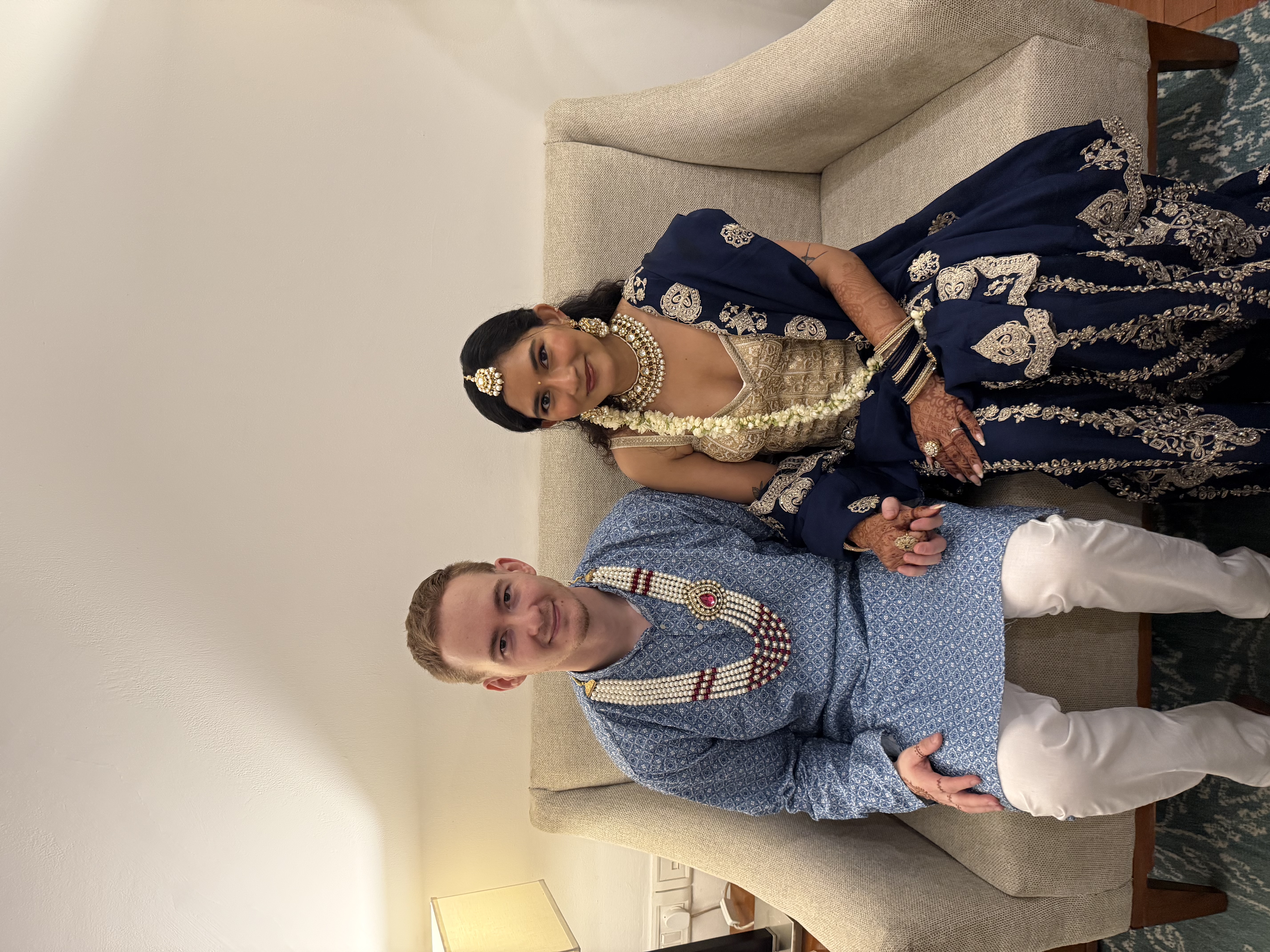 Monica and Romain seated together in traditional attire