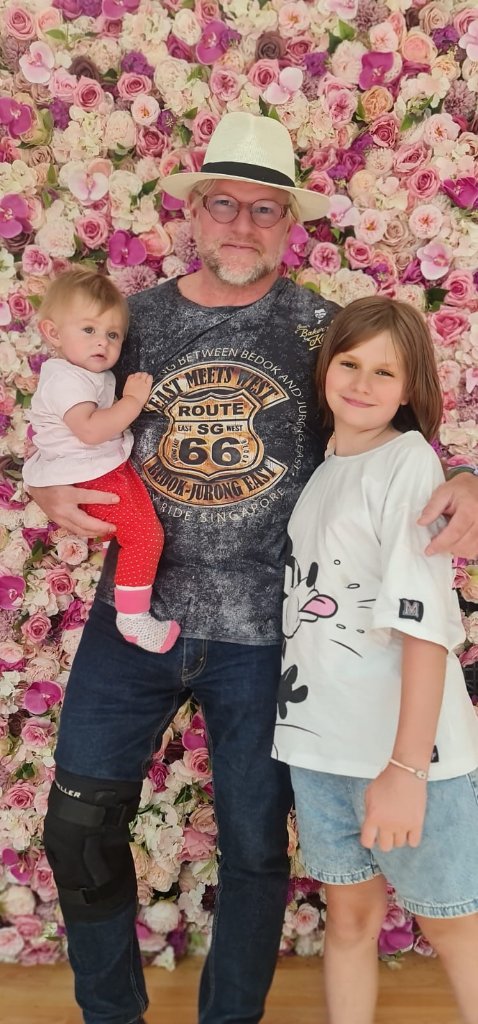 Sven mit Kindern vor Blumenwand