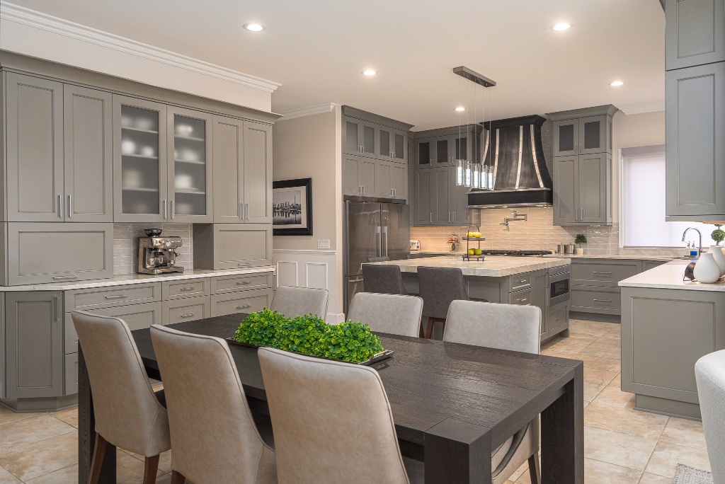 Transitional sage-grey kitchen with custom black range hood and turret dining nook
