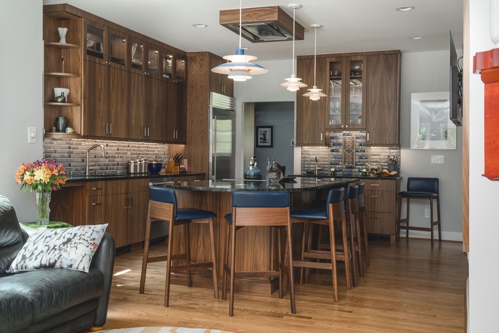 Mid-century walnut kitchen with navy leather island seating and blue-green mosaic backsplash