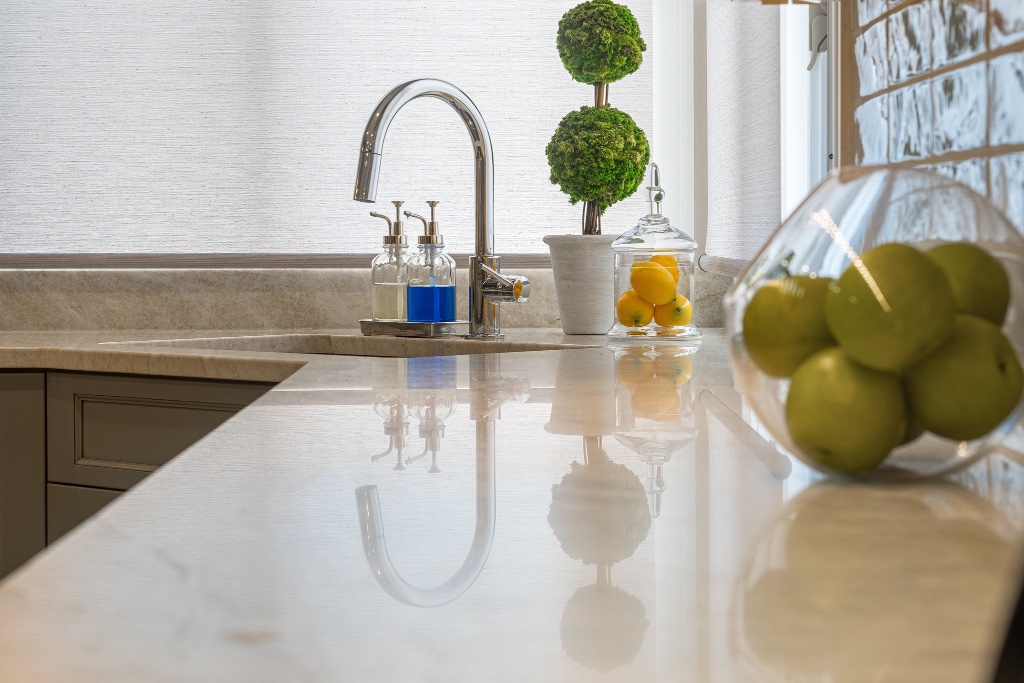 Cream stone countertop with subtle veining and polished chrome fixtures