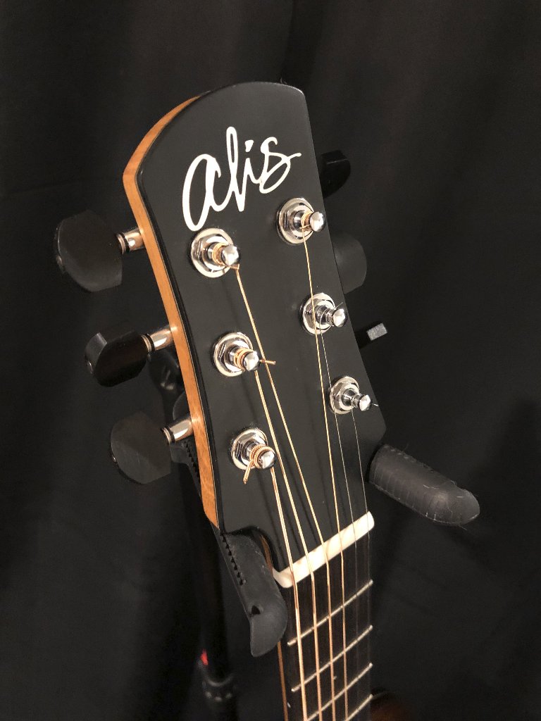 Black guitar headstock with the "alis" logo