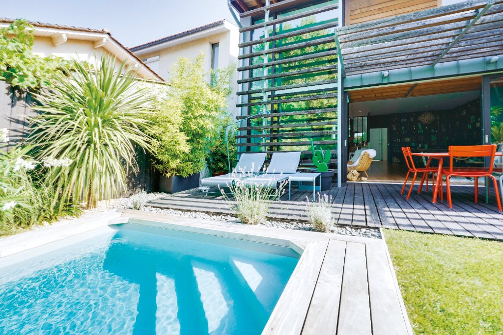 Outdoor living pool design with modern home