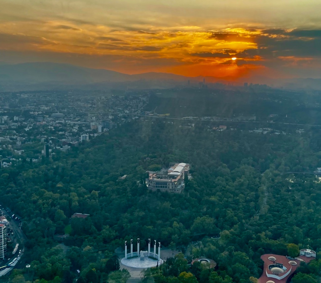 Vista aérea del Castillo de Chapultepec entre el bosque al atardecer dorado, Ciudad de México