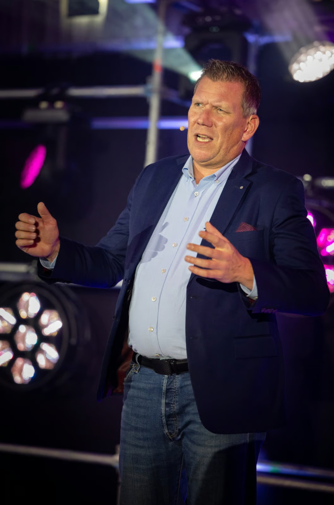 André Hennig auf der Bühne beim Vortrag vor professionellem Publikum