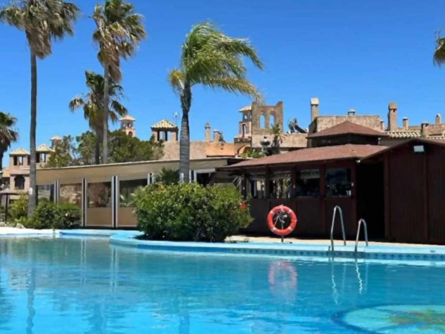 Piscina y chiringuito con palmeras