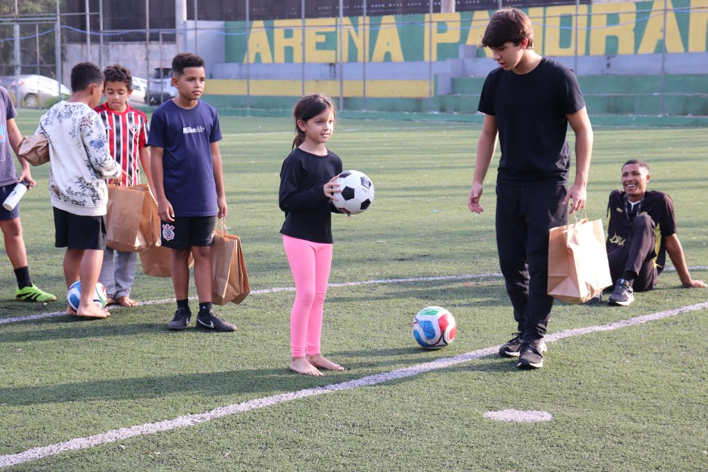 Jovem segurando bola de futebol