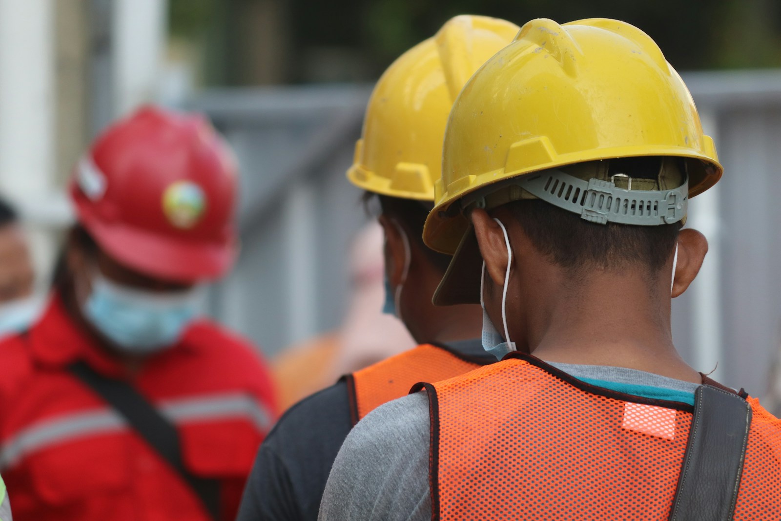 Construction crew wearing hard hats and high-visibility safety gear