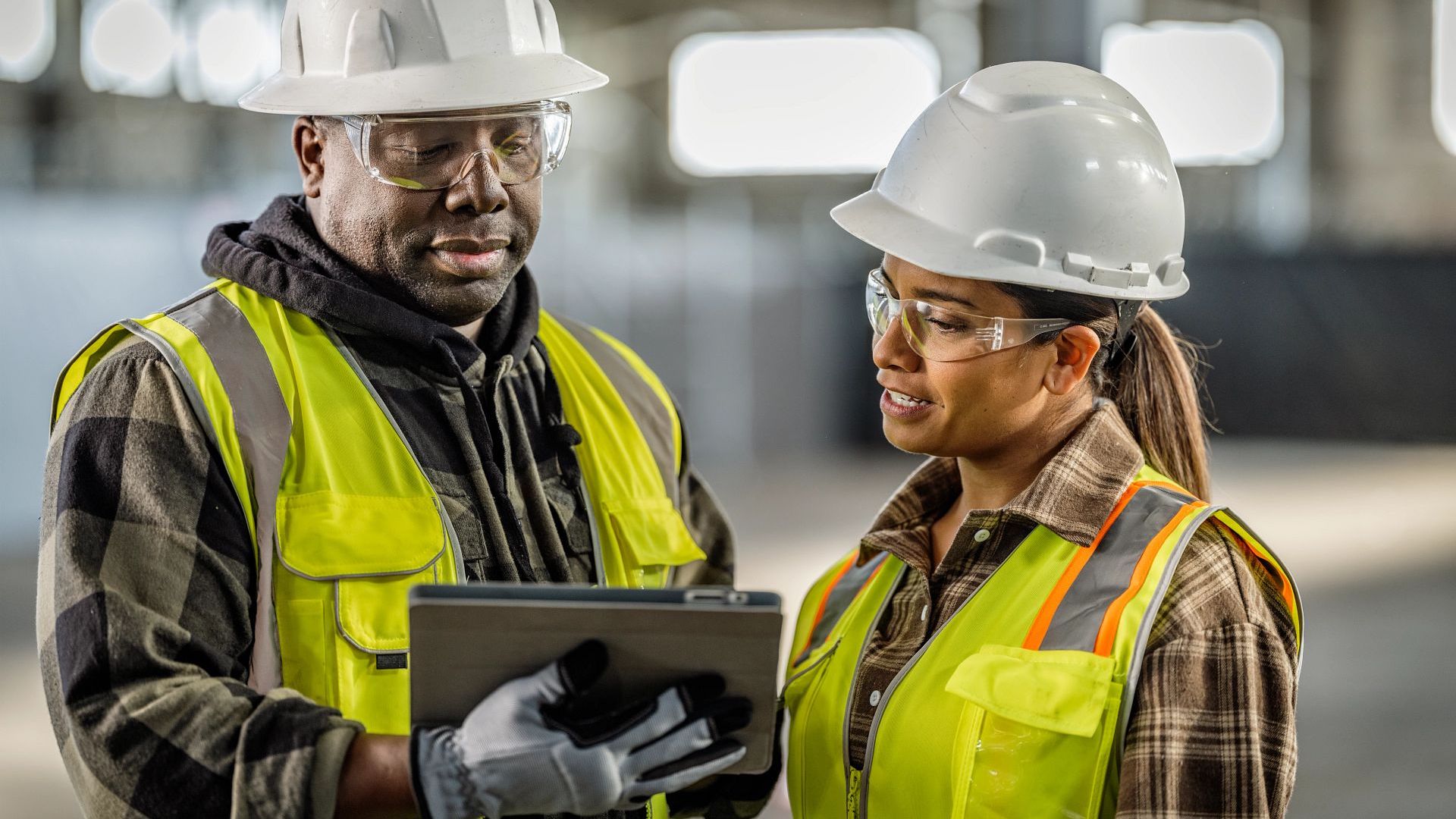 Two construction professionals reviewing information together on a tablet