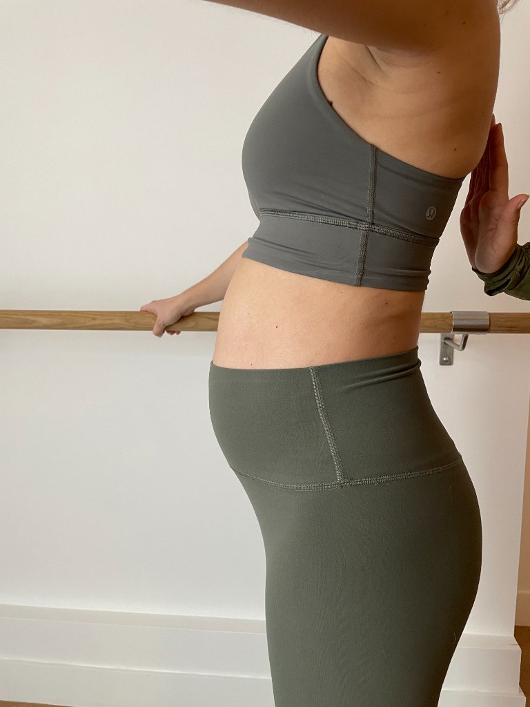 Pregnant woman doing barre exercise with trainer