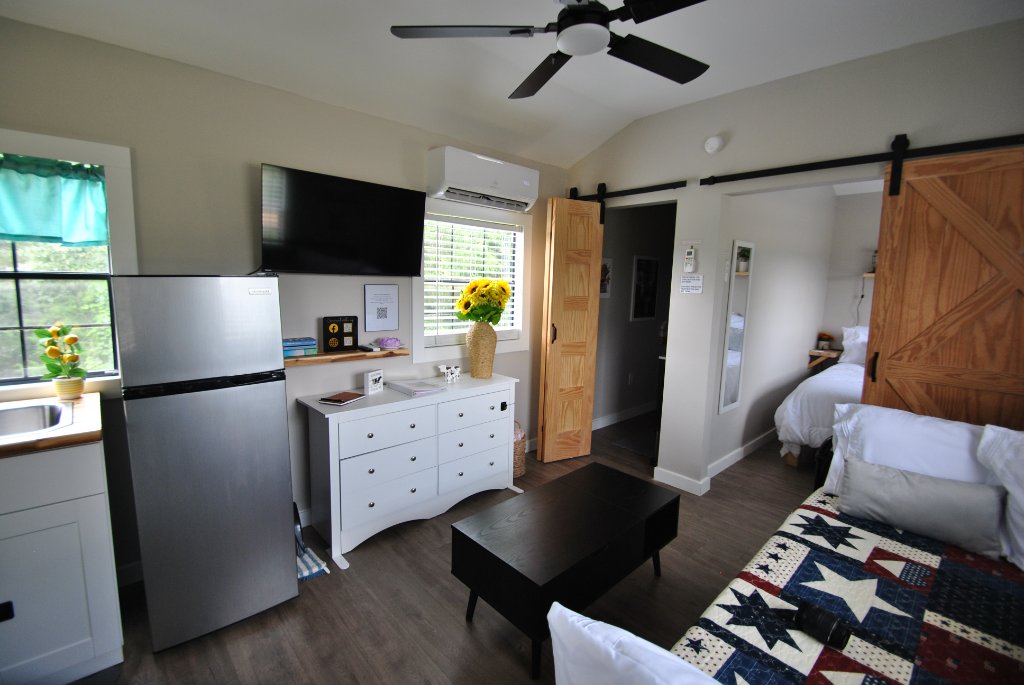 Warm minimalist interior of the Cloud Nine tiny house with shiplap walls, wood ceiling beams and panoramic Alabama views