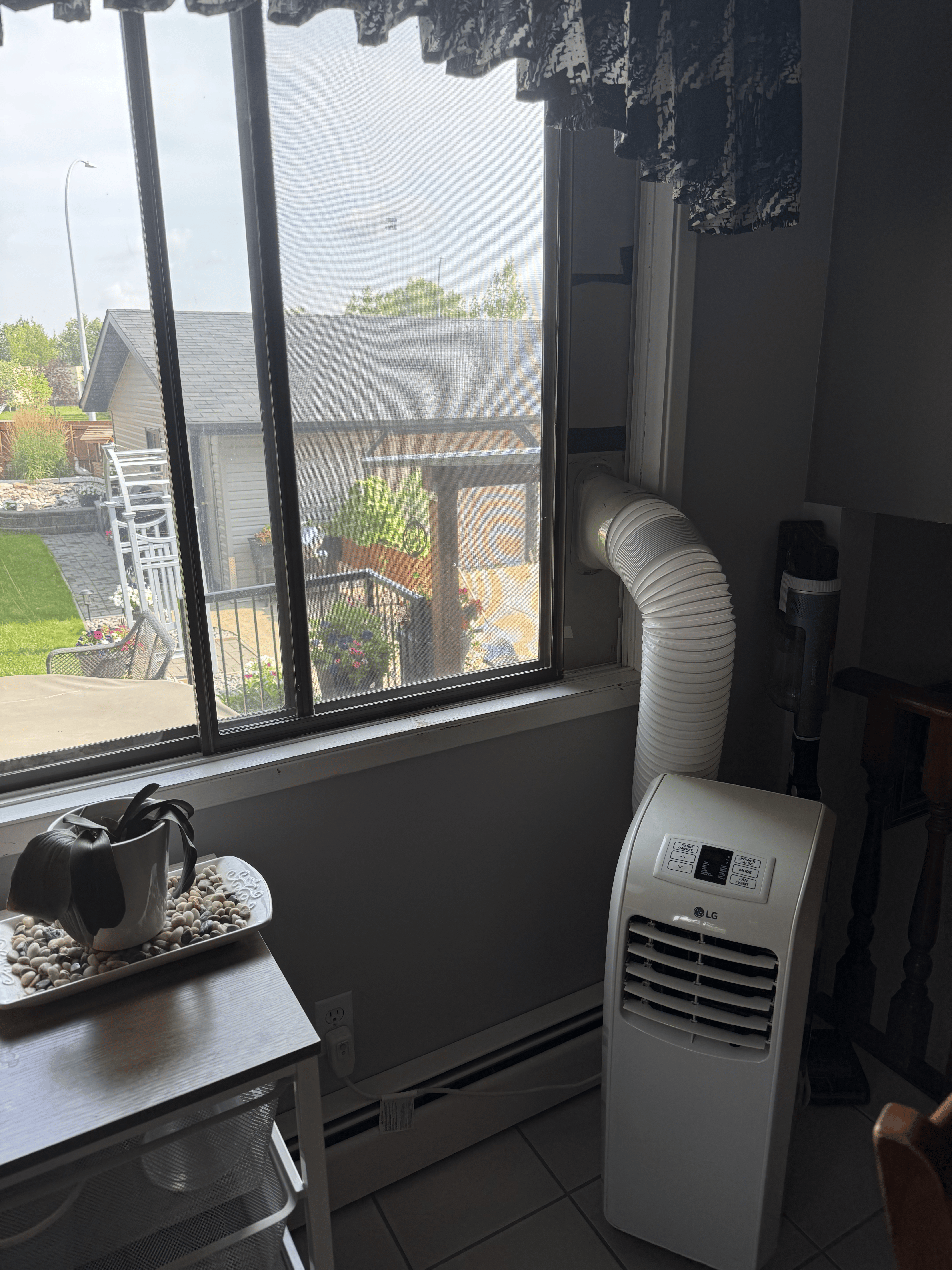 Portable AC exhaust hose venting through an open window