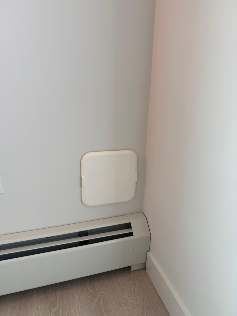 Air Socket wall outlet installed in a bedroom, exhaust hose connected to a portable AC