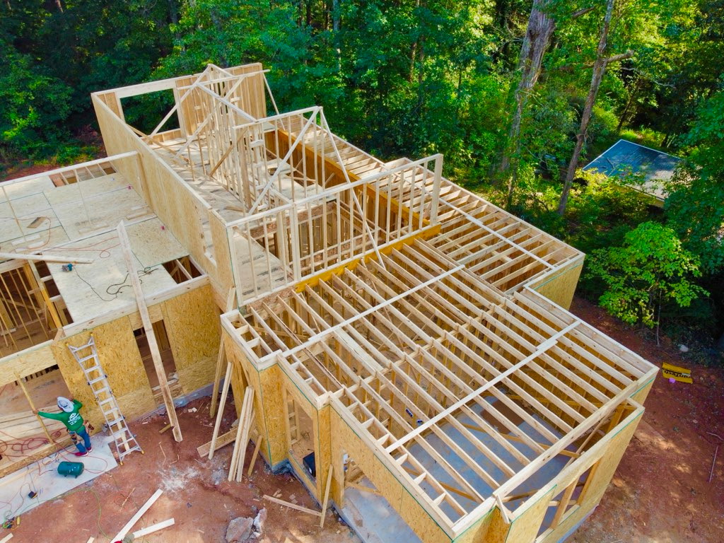 Framing progress at 56 Cooper Lake Rd SW, September 18, 2026 — Side view — wall framing and exposed joists reveal the home's layout.