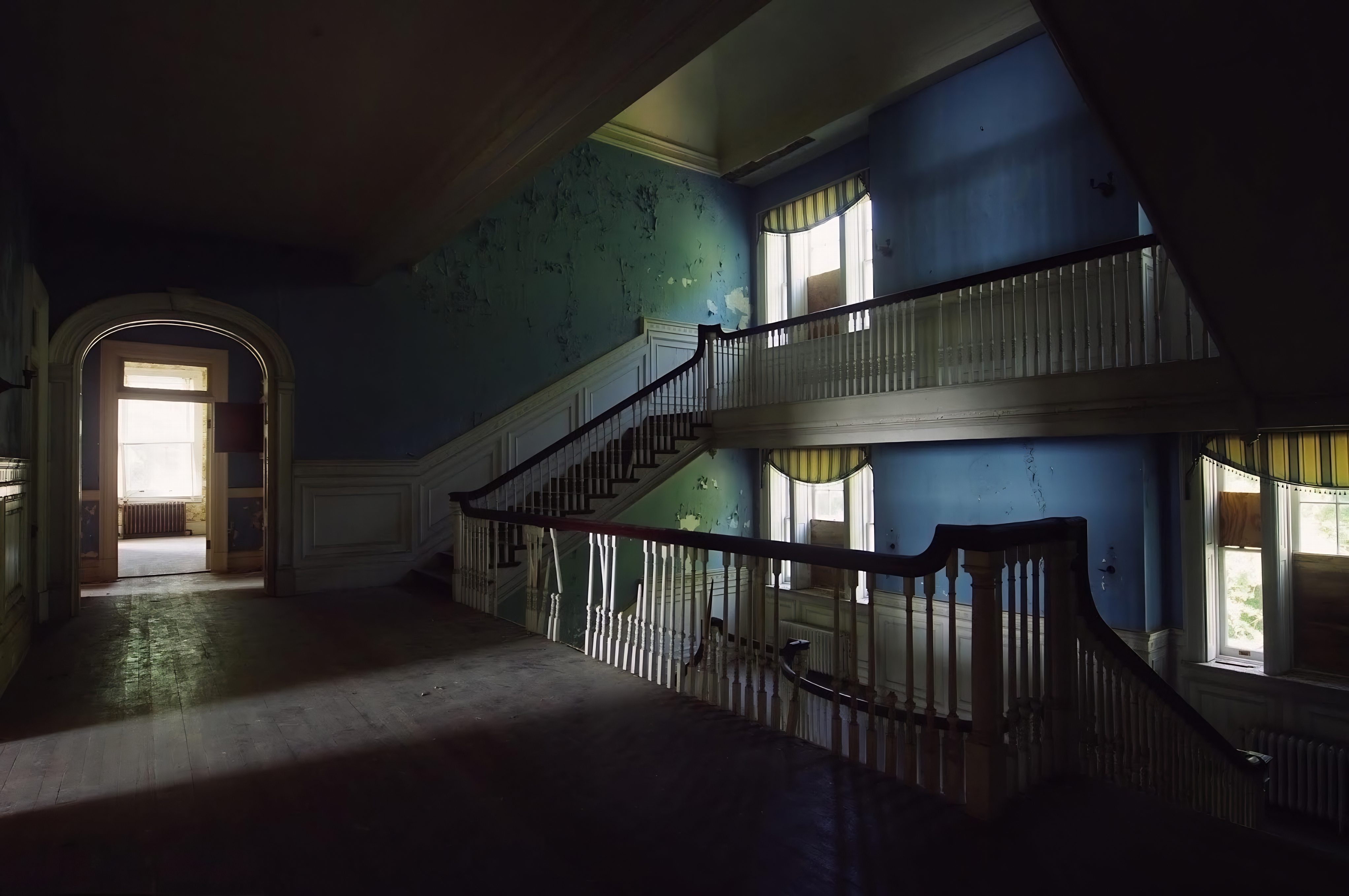 Selma Mansion staircase landing with peeling teal walls and striped valances