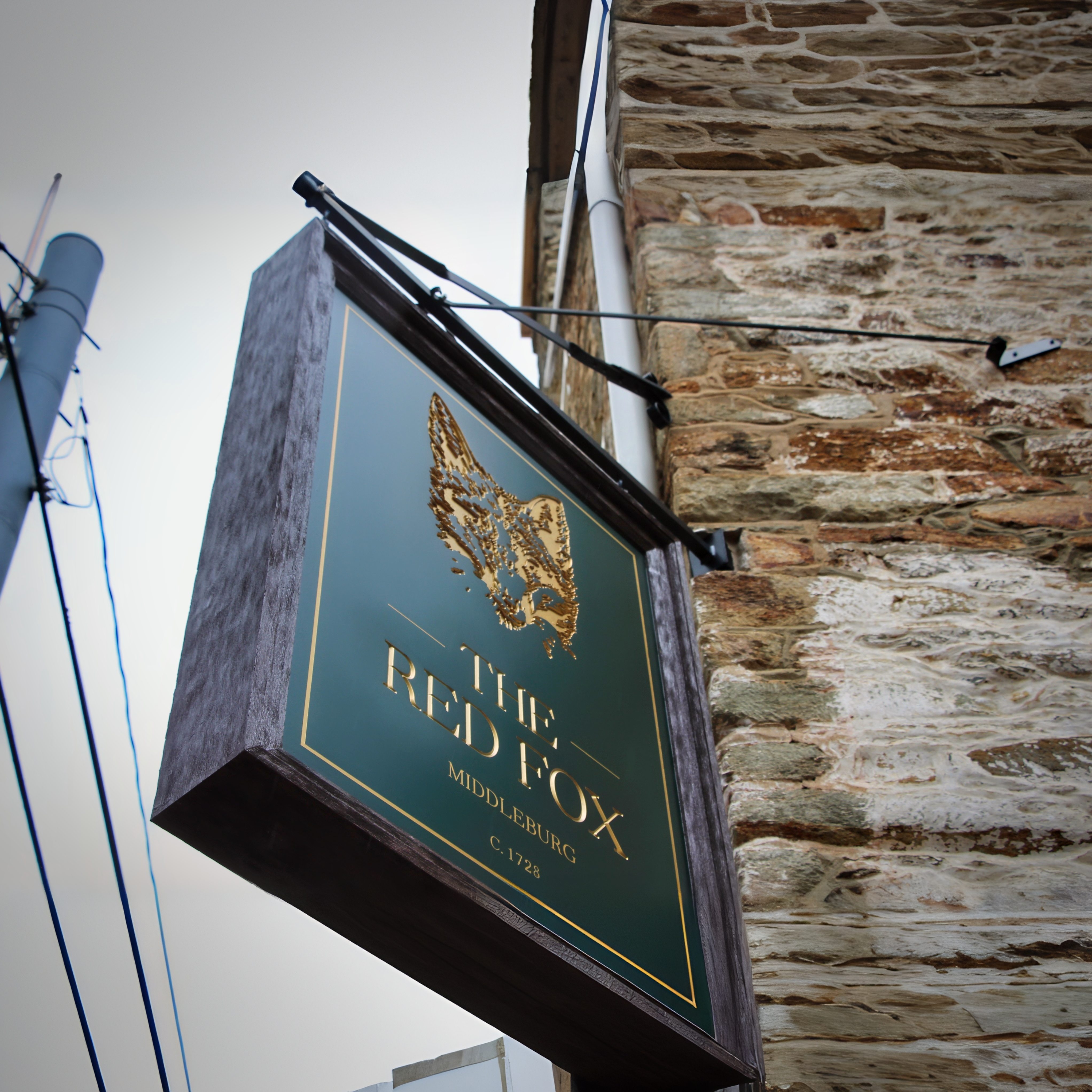 The inn’s sign: a gold fox, a green board, and a date older than the republic.