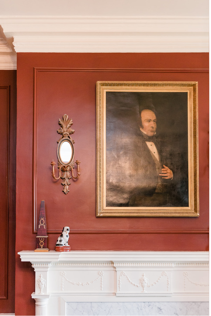 The mantel in the Colonel's study — dentil shelf, fluted pilasters, and a festooned frieze, presided over by Ludwell Lee's portrait.