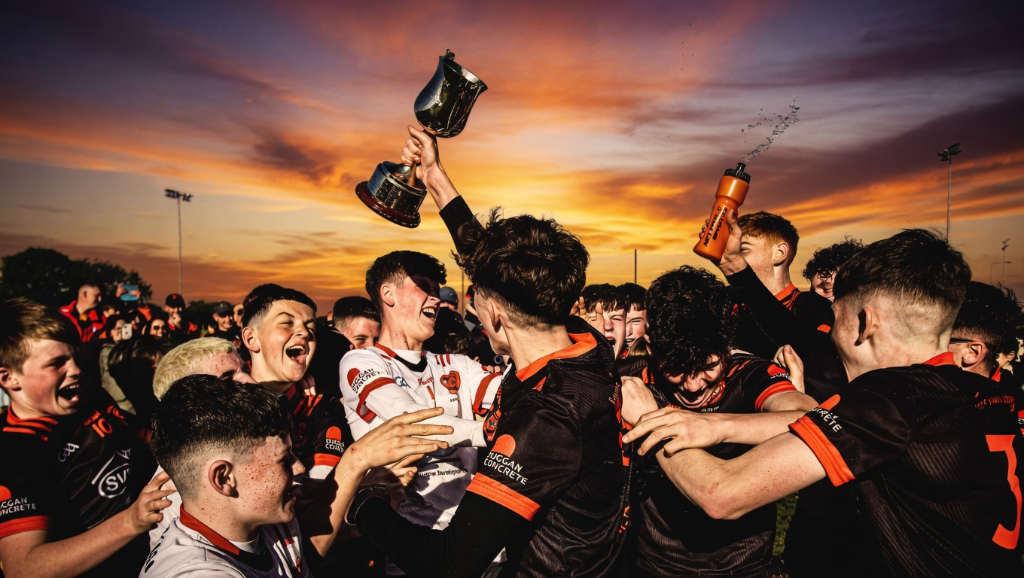 Youth GAA team celebrating a victory at sunset