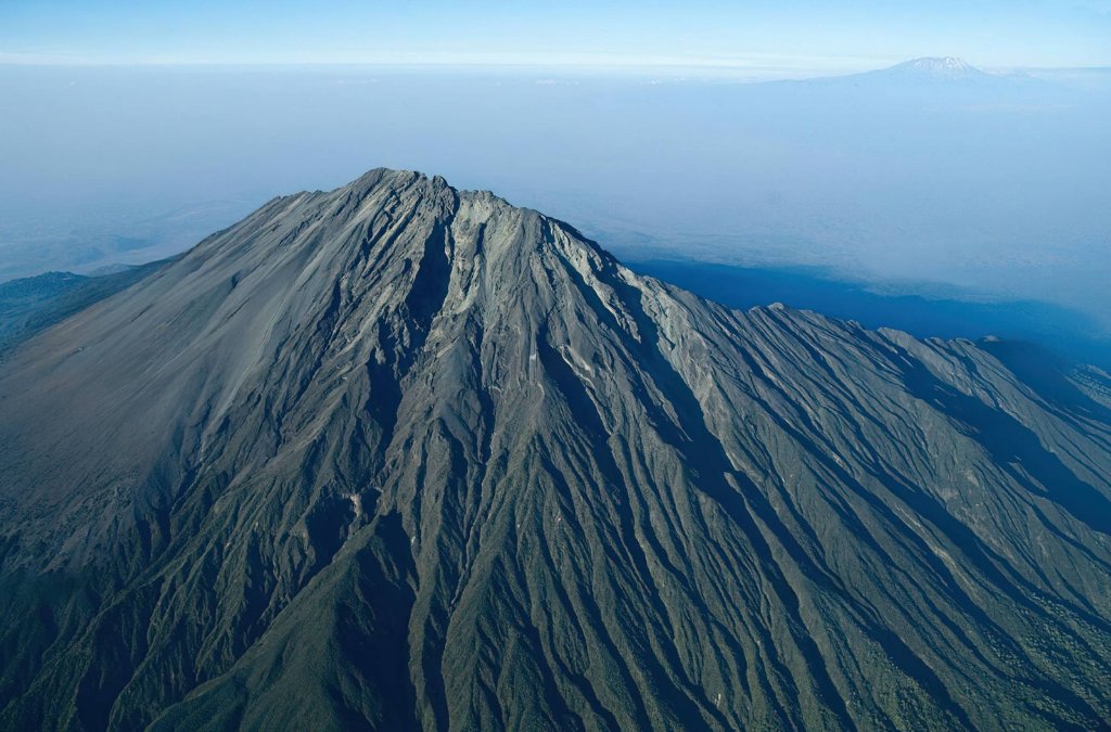 Mount Meru summit crater with view towards Kilimanjaro at dawn
