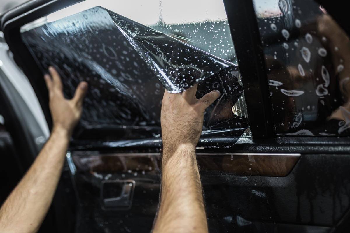 Technician applying window tint film