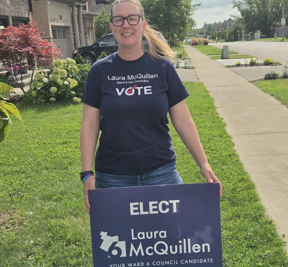 Laura McQuillen holding a campaign sign