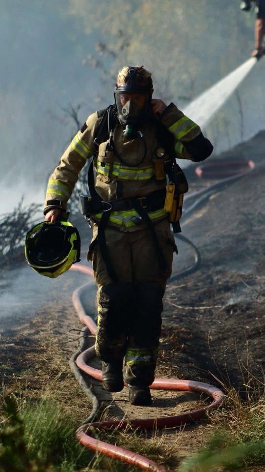 One of our favourites: A firefighter removes their BA set after the fire. Photograph by Mason.