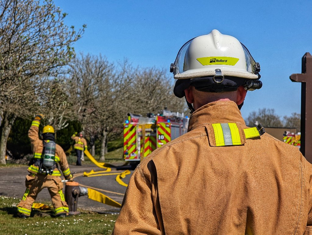 Stretching a line from the engine to the hydrant - the captain watches on