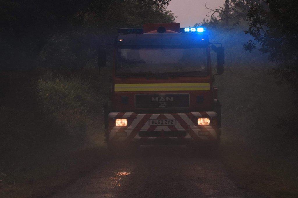 A Water Carrier makes its way down a smoke-logged back lane to the scene of a grass fire